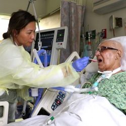 Effects of PMV® In-line with Mechanical Ventilation on Communication and Swallowing Caregiver assisting in feeding bed ridden patient with a PMV007 inline